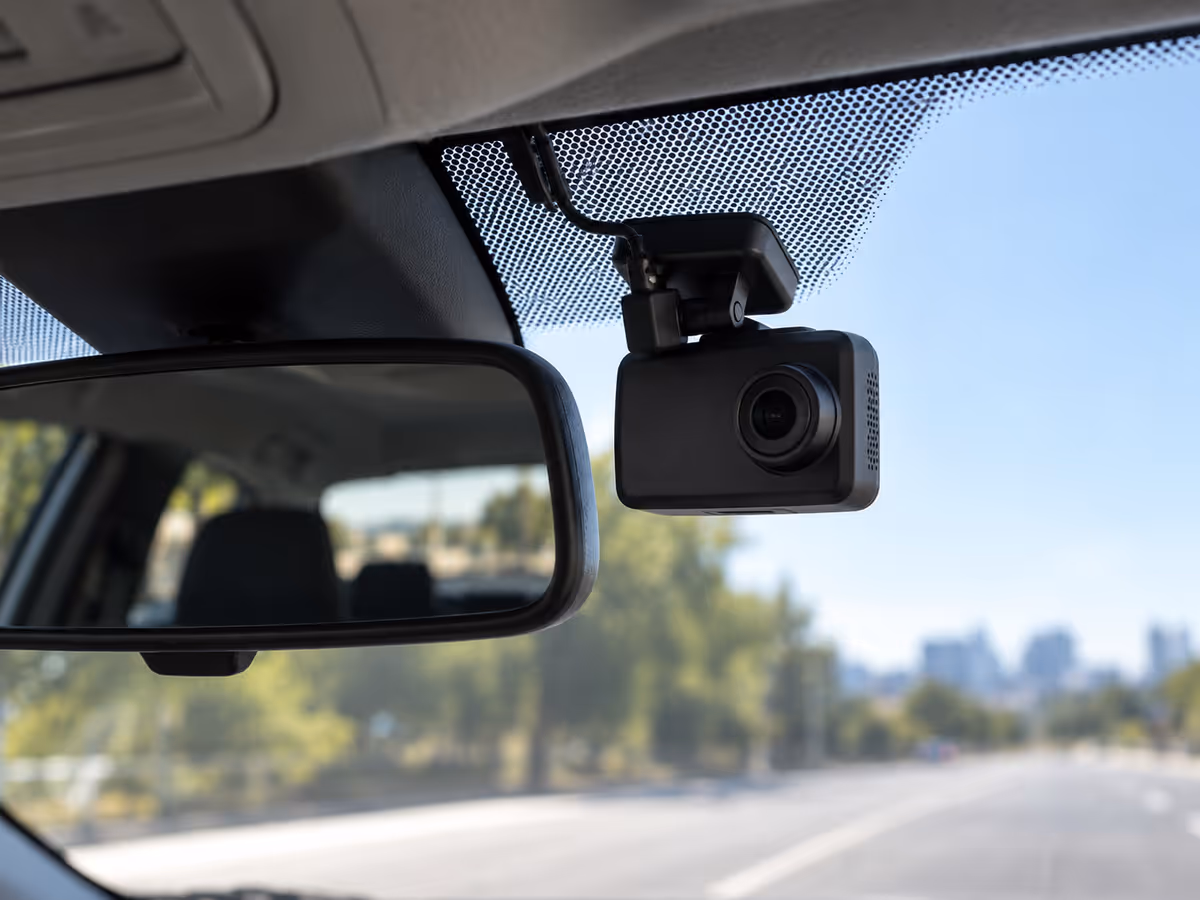 A compact camera sits beside the rearview mirror.